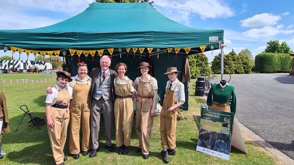 Illustrator John Thurman stands with Holly Brega and the Suffolk Women’s Land Army group at the Rowley Mile Racecourse in Newmarket, 14th May 2022. Chesnut and Daphne Book launch.